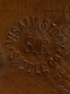 Visalia Stock Saddle Company stamp. Close up of leather stamp reading Visalia Stock Saddle Co with SF in the middle