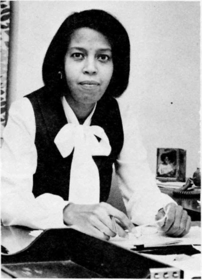 Mary E. Jackson looking up from papers on her desk towards the camera.