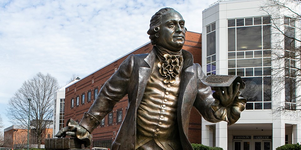 George Mason statue Statue of Mason standing leaning forward presenting a piece of paper.