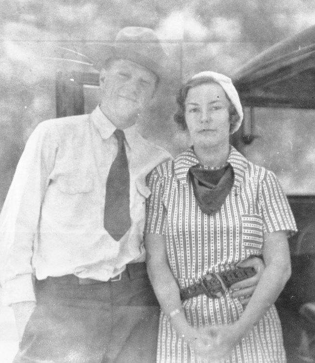 Man in a ranger uniform with his arm around a woman in a striped dress.