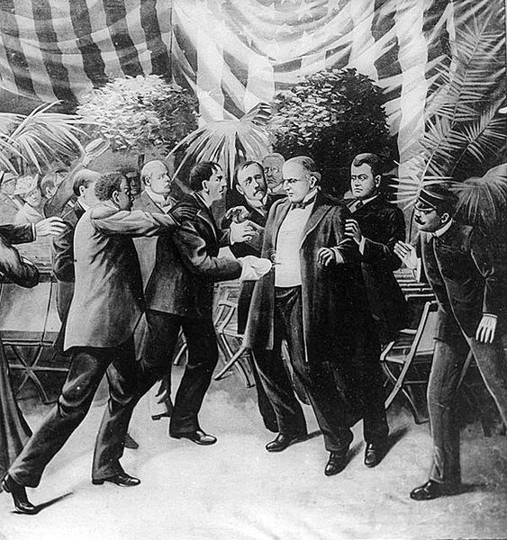 President McKinley is surrounded by men as he staggers from a gunshot