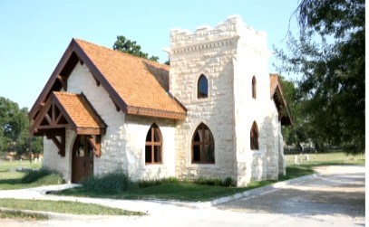 A small stone chapel, painted white, with a wooden roof.