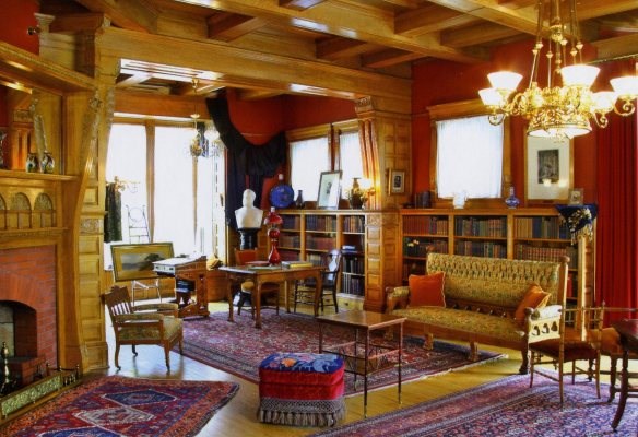 memorial-library a room with bookcases, a table and a red chair