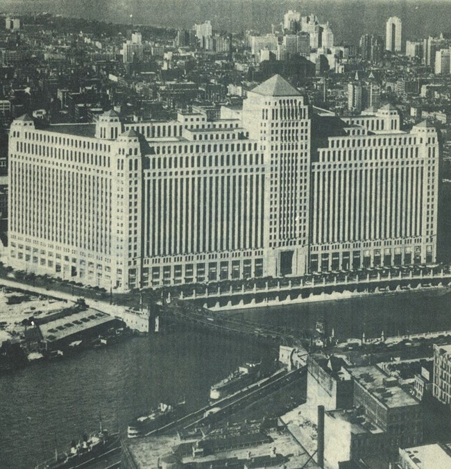 Huge eight story building with a tower sited on the edge of a river