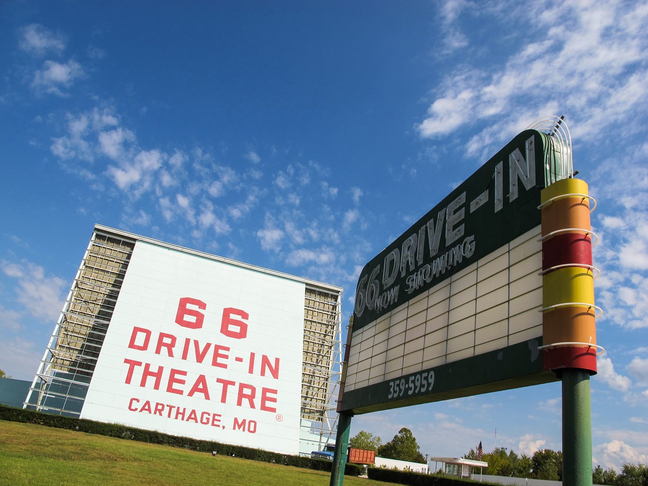 A large white board reads in red text "66 Drive-In Theatre Carthage, MO". Next to it is a black letter board sign.
