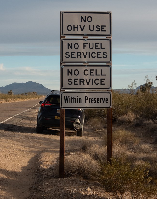 lt= signboard that reads "no OHV use, no fuel services, no cell service within preserve"