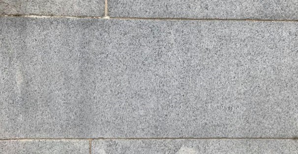monument block Close-up image of a granite block that is a part of a monument. Thin lines of mortar outline the block.