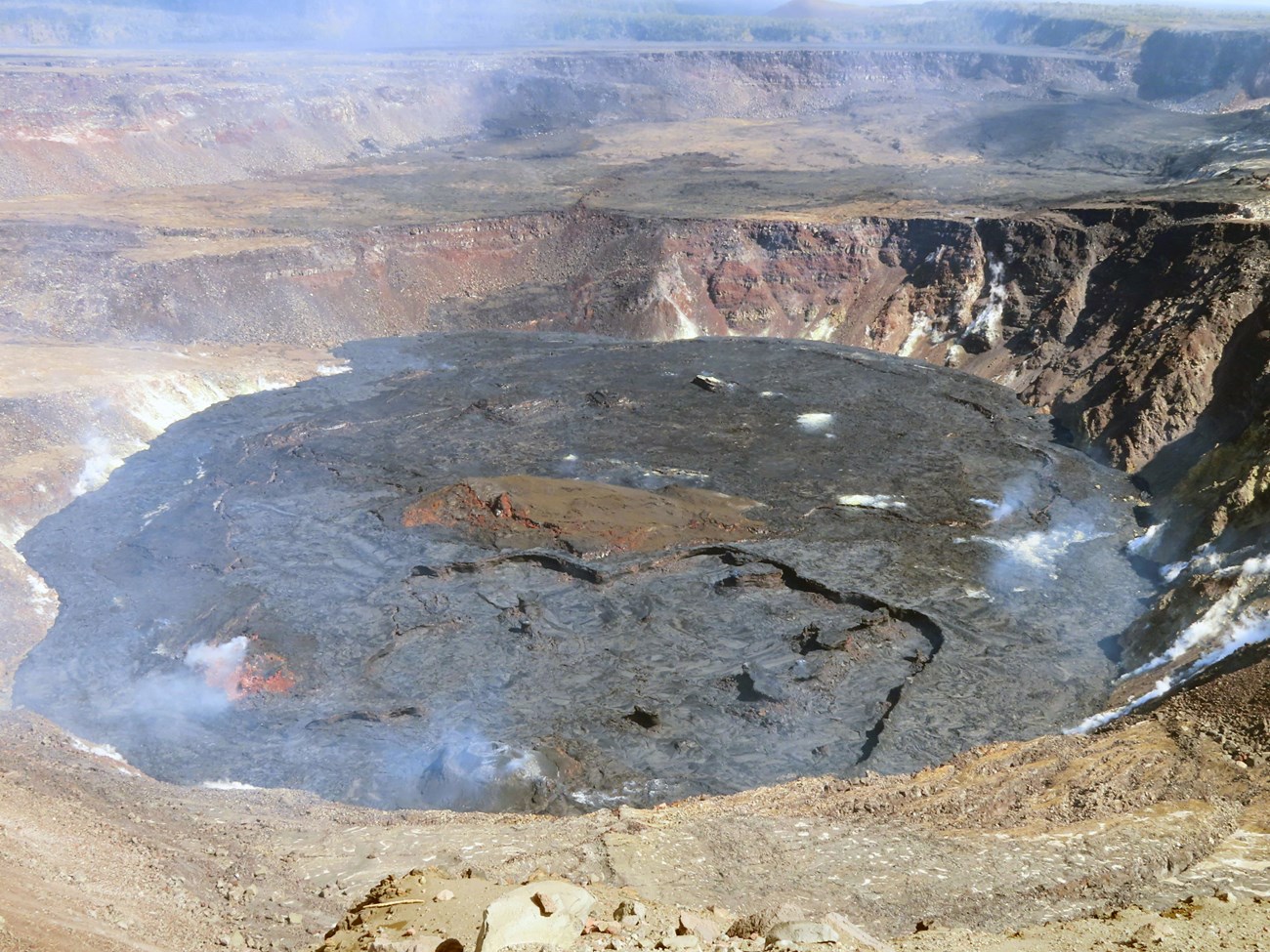 photo of a crater with a flat bottom where it has been filled by lava
