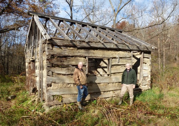muskingumcountyauthor a wooden frame of a home with two men standing in front of it