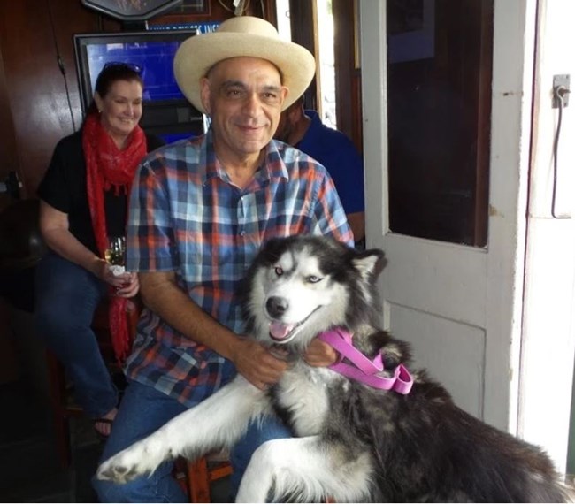 Frank Perez with his dog and a patron at a bar in New Orleans.