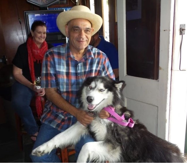 Frank Perez, President of the LGBTQ+ Archives Project of Louisiana Frank Perez with his dog and a patron at a bar in New Orleans.