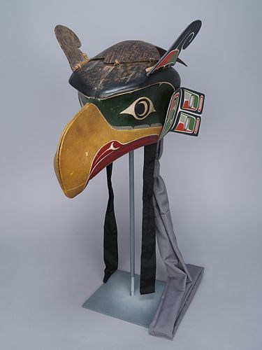Thunderbird Headdress made by Herbert Johnson (MOA ID# A4500). A bird headdress with a long yellow beak, red throat, green head, and dark-hair and winged ears.