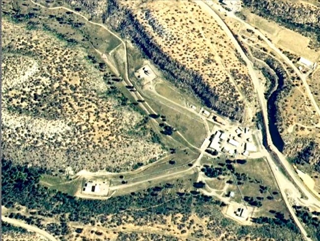 View shows a cluster of buildings, roads, and sparsely vegetation landscape