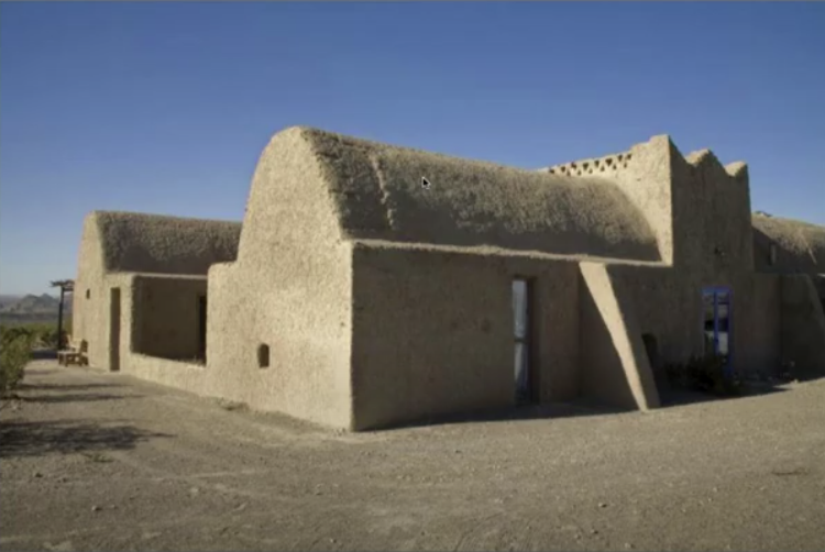 Adobe longhouse with a tall cone-shaped vaulted roof.