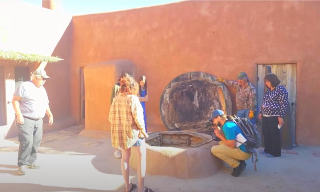 A group of adult students gather by a well on one of O'Keeffe's properties.