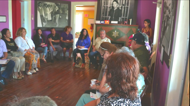Storytelling, an oral history program at the Esperanza. A group of elders and youth sit in a circle of chairs to share experiences.