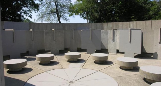 In a round Poured concrete stools in a circle with showers and changing stalls.