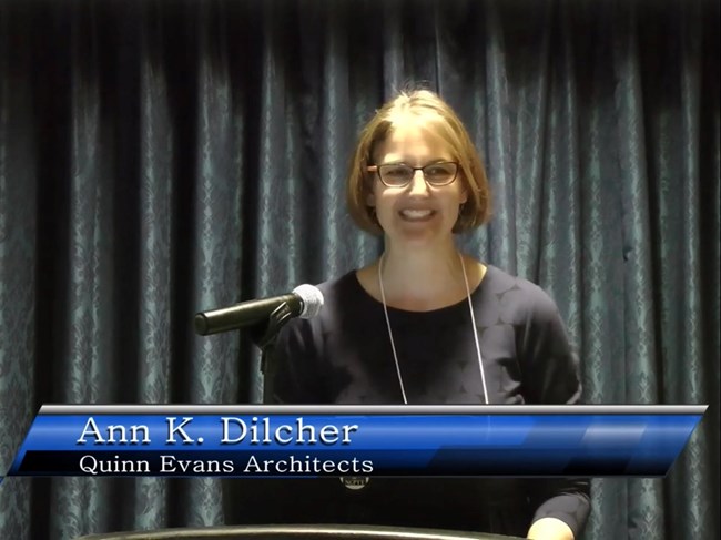 Ann Dilcher stands at a lectern, presenting.