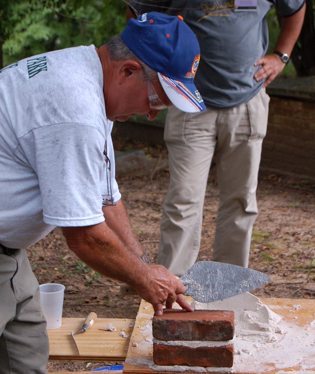 Dom DeRubis demonstrates brick laying at an NCPTT training.