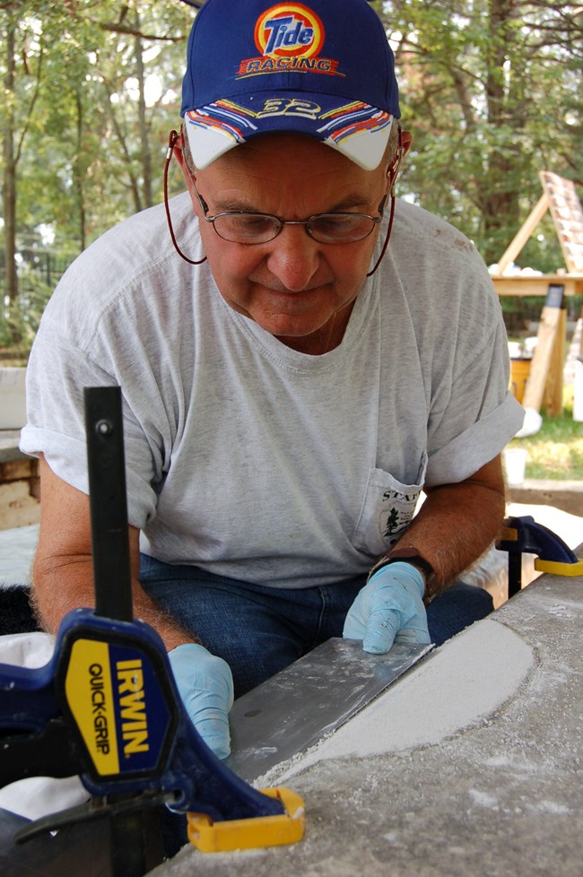 Dom DuRubis patching a marble tablet.