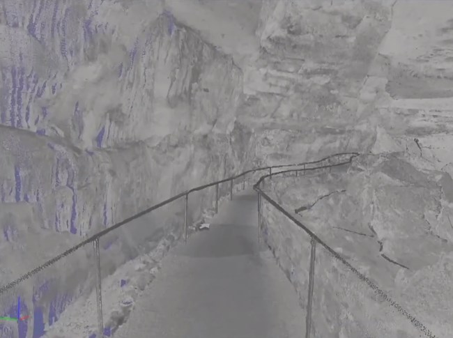 Blue artifacts are caused by no scan data, sections in shadow to the scanner. A level walkway showing circles where the scanner sat, parts of cavern walls in blue.