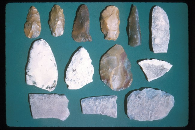 a collection of various worked stones laid out on a cloth surface.