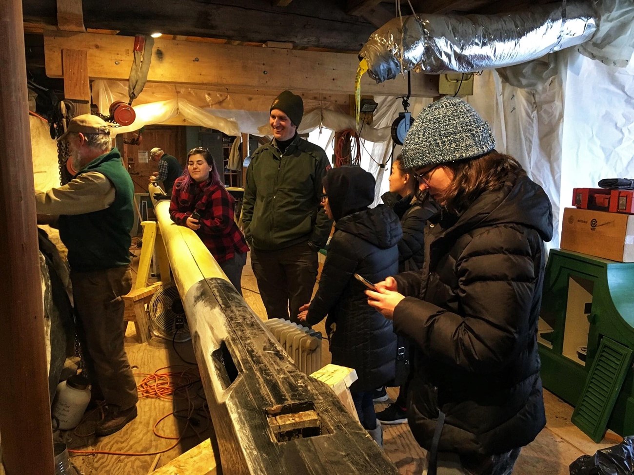 people stand inside a wood workshop