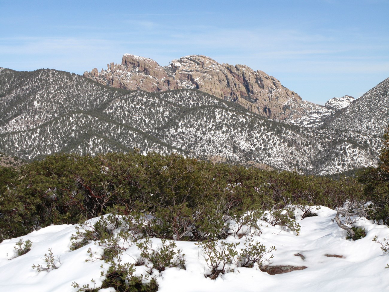 A bald, rocky mountain (Cochise Head) rises above snowy hills.