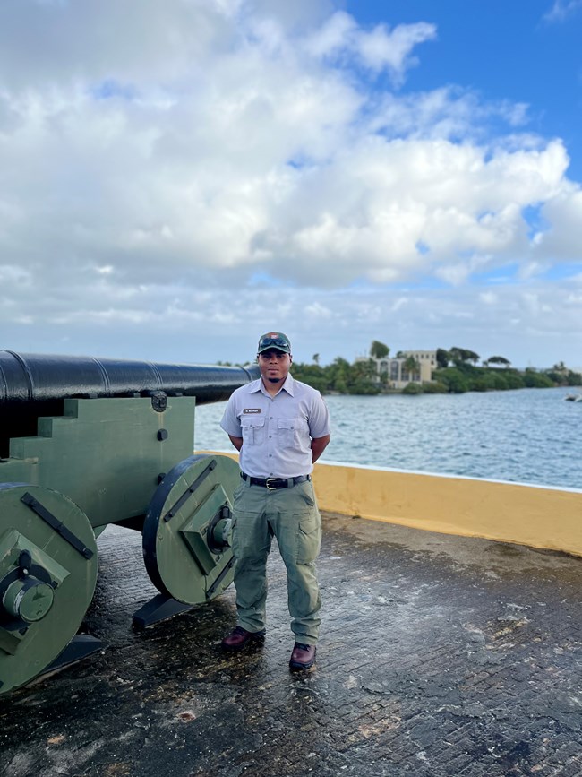 National Park Service Employee in uniform standing next to a historic cannon