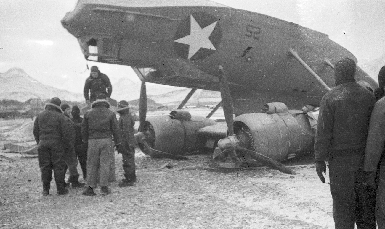 Overturned PBY About 10 men standing around an overturned plane.