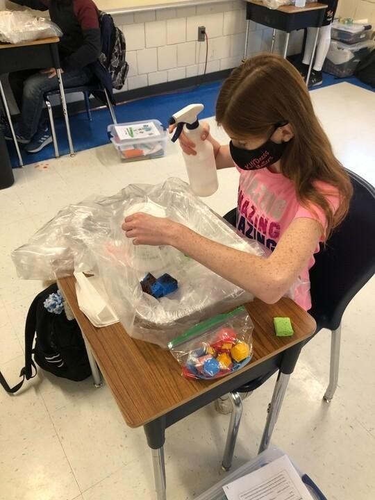 A student works on their watershed model for a Riverschools class. Using a sprayer, water travels around the model, as it would in a watershed. With different household items, like sponges and food dye, the students learn how watersheds work. Photo credit