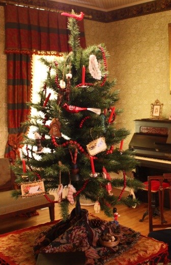 parlortree table top Christmas tree with ornanments on the branches.