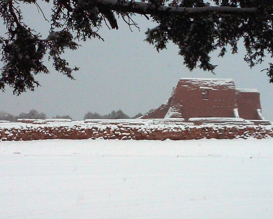 Mission church after snowfall snow covered field, rock wall, and mission church ruins