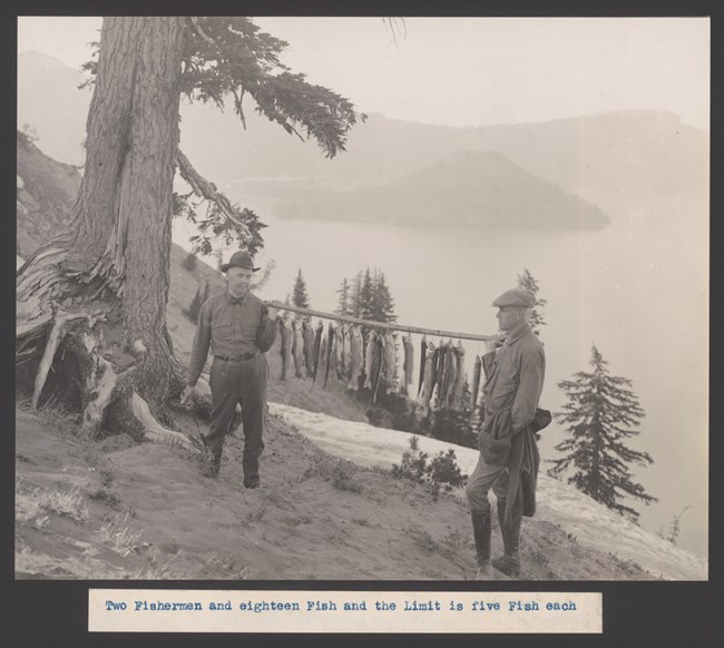Crater Lake fishing Two fishermen holding a catch of 18 fish on a stick.