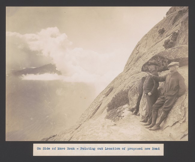 Two men standing on the side of a rock outcrop