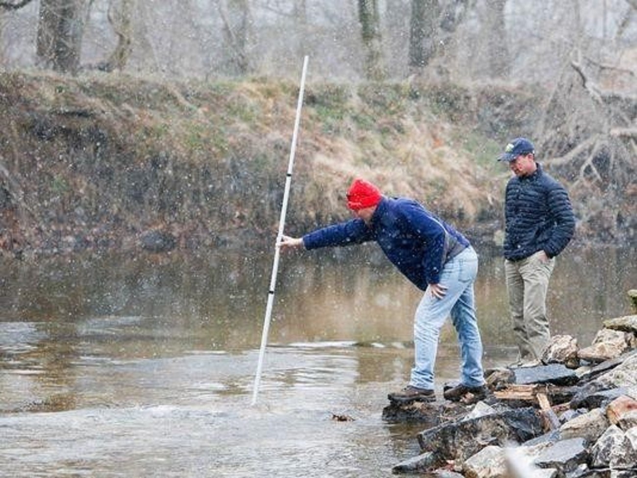 Jerry Kaufman stands next to Andrew Homsey as he measures the water depth where Byrnes Mill dam, Dam #1, once stood. Photo Credit: Jerry Kaufman Jerry Kaufman stands next to Andrew Homsey as he measures the water depth where Byrnes Mill dam, Dam #1, once stood. Photo Credit: Jerry Kaufman