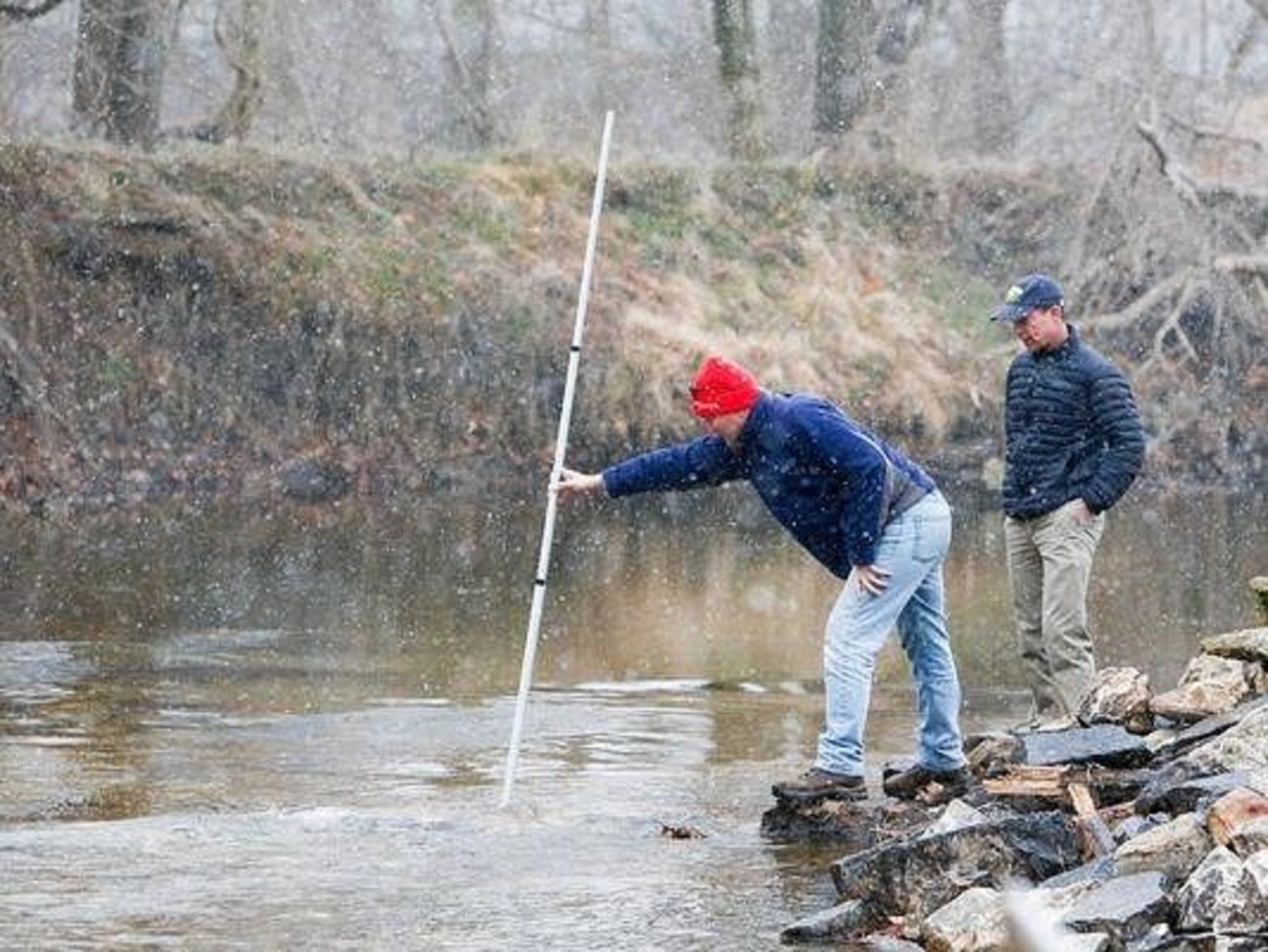 Jerry Kaufman stands next to Andrew Homsey as he measures the water depth where Byrnes Mill dam, Dam #1, once stood. Photo Credit: Jerry Kaufman