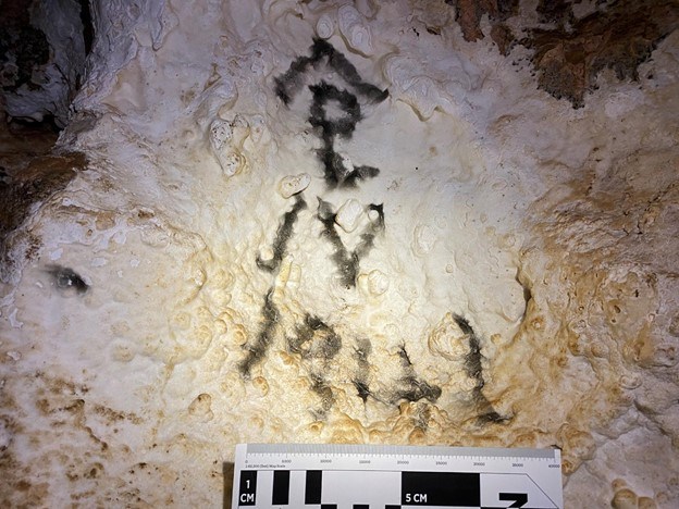 A potential cattle brand written on cave wall using carbide.