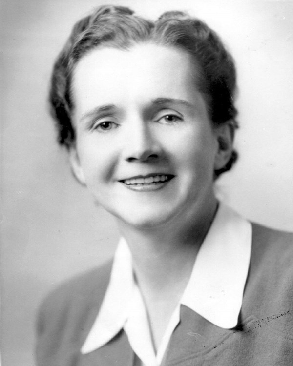 Black and white portrait of a woman smiling at the camera.