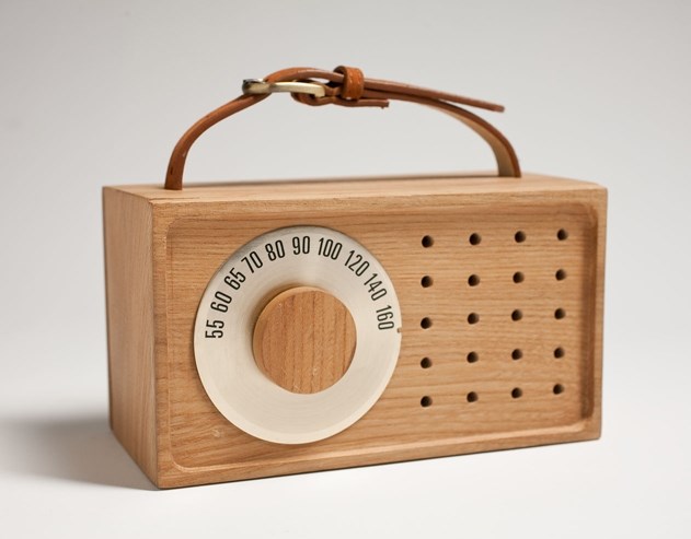 radio Wooden box radio, with leather strap at top to hold, hallow small circles, and a knob that can be adjusted to different numbers