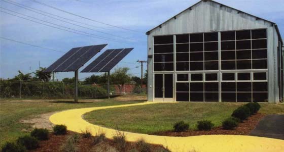 pole-mounted array of solar panels next to a railway barn