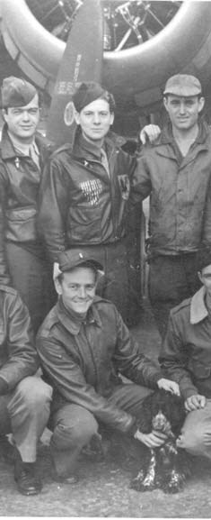 four men in uniform stand in front of an aircraft