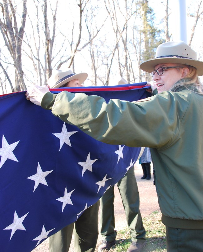 Park ranger folding American flag Park ranger folding American flag with blue field showing.