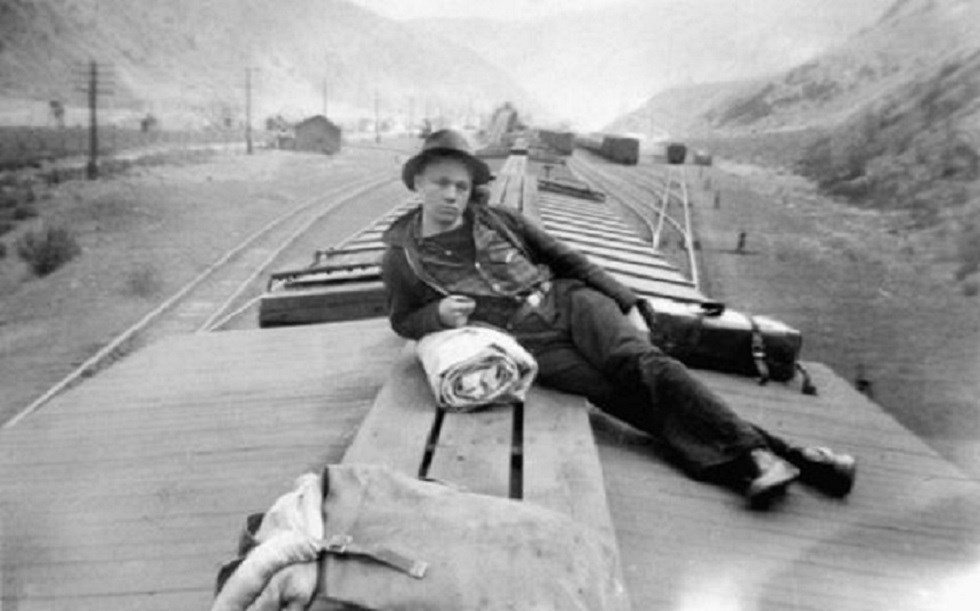 Black and white photo of man on top of a train