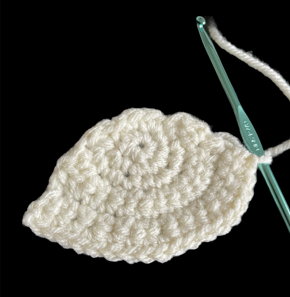 White yarn that has been crocheted together to form a semi circle.