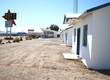 lt= Dirt lot in front of a historic one-story motel.