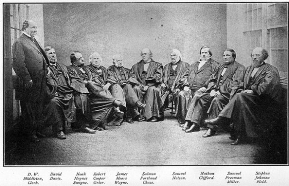 a group of men sitting in a semi circle all in suits