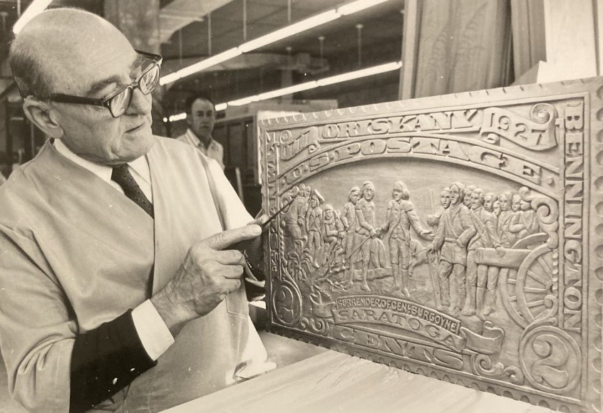 John Segeren and his carved Saratoga stamp. John Segeren posing with a large carved wooden stamp.