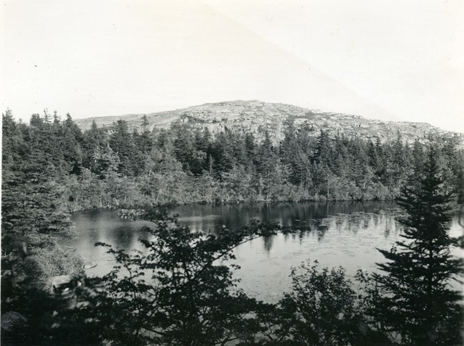 B&W photo of pond with granite summit in background