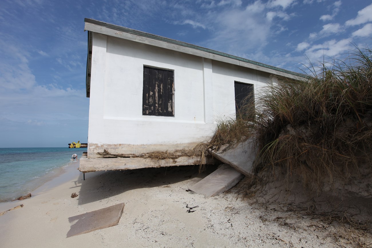 Dry Tortugas Light Station Boat House, Loggerhead Key View of boathouse showing stabilizing structures on a bluff by the beach.